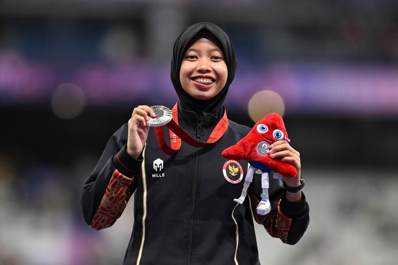 Sprinter Indonesia Karisma Evi Tiarani memamerkan medali yang diperoleh dari pertandingan final nomor 100 meter T63 putri Paralimpiade Paris 2024 di Stadion Stade de France, Paris, Prancis, Sabtu (07/09/2024). Karisma Evi berhasil finis di urutan kedua dan berhak atas medali perak dengan catatan waktu 14,26 detik. ANTARA/HO/NPC INDONESIA/Agung Wahyudi