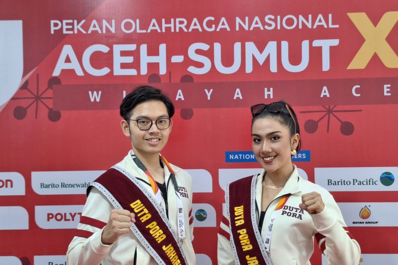Duta Pora Jakarta, Tabitha Napitupulu (kanan) bersama dengan Duta Pora Jakarta, Raden Alfin Dwisatrio Dutapora saat memberikan dukungan pada kontingen basket Jakarta di pertandingan semifinal PON Aceh-Sumut 2024 di GOR Harapan Bangsa, Minggu (8/9/2024). (ANTARA/FAJAR SATRIYO)