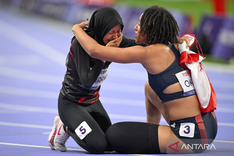 Sprinter Karisma Evi Tiarani (kiri) menangis terharu dalam pelukan sprinter Britania Raya Ndidikama Okoh (kanan) setelah berhasil finis di urutan kedua pada pertandingan final nomor 100 meter T63 putri Paralimpiade Paris 2024 di Stadion Stade de France, Paris, Prancis, Sabtu (07/09/2024). Karisma Evi berhasil finis di urutan kedua dan berhak atas medali perak dengan catatan waktu 14,26 detik. ANTARA FOTO/Agung Wahyudi/app/agr