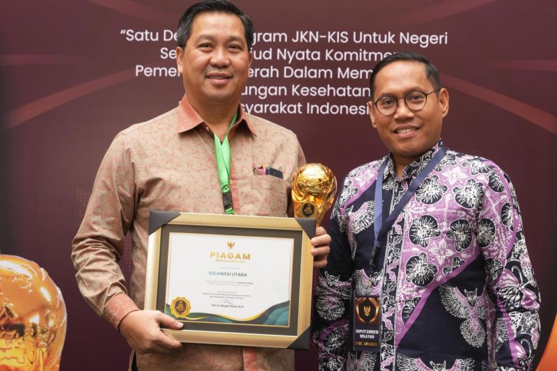 Deputi Direksi BPJS Kesehatan Wilayah X, Octovianus Ramba (kanan) mendampingi Wakil Gubernur Sulut Steven Kandouw (kiri) pada penganugerahan UHC bagi pemerintah daerah. ANTARA/HO-BPJS Kesehatan
