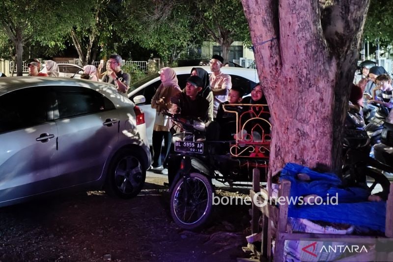 Warga Banda Aceh menonton siaran pembukaan PON XXI Aceh-Sumut 2024 dari tepi jalan di samping Lapangan Bank Aceh Expo, Banda Aceh pada Senin (9/9/2024). (ANTARA/Farhan Arda Nugraha)