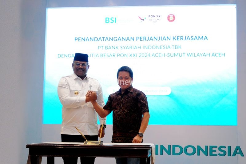 Direktur Utama BSI Hery Gunardi (kanan) berjabat tangan dengan (Pj) Gubernur Aceh Safrizal ZA pada seremoni penandatangan kerja sama antara BSI dengan PB PON XXI 2024 Aceh Sumut Wilayah Aceh yang berlangsung di Gedung Landmark BSI Aceh, Selasa (10/9/2024). ANTARA/HO-BSI