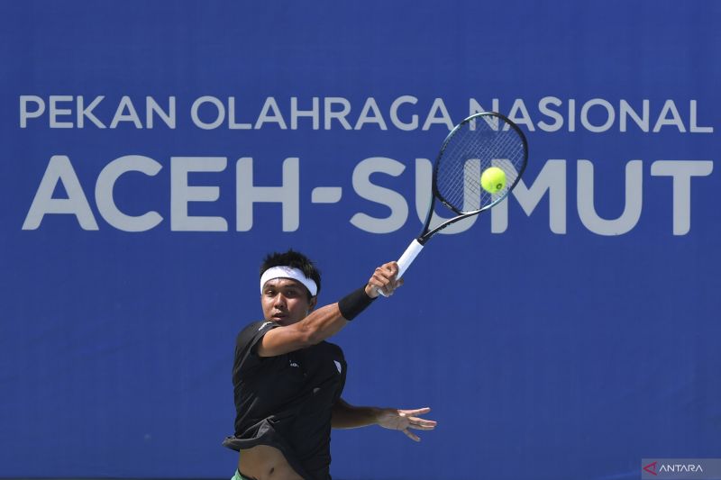 Petenis tunggal putra Jawa Timur M Rifky Fitriadi mengembalikan bola ke arah lawannya petenis Sulawesi Selatan Ahmad Noval Luckynanda Karim pada pertandingan penyisihan beregu PON XXI Aceh-Sumut 2024 di GOR Stadion Harapan Bangsa, Banda Aceh, Aceh, Selasa (10/9/2024). M Rifky Fitriadi menang dengan skor 6-0, 6-1. ANTARA FOTO/ Adeng Bustomi/aww. (ANTARA FOTO/ADENG BUSTOMI)