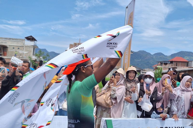 Atlet Jawa Timur, Binta Erlen Salsabila berselebrasi usai mencapai garis finis dengan catatan waktu tercepat pada nomor standar putri triathlon Pekan Olahraga Nasional (PON) XXI Aceh-Sumut 2024 yang berlangsung di Danau Lut Tawar, Takengon, Aceh, Rabu (11/09/2024). (ANTARA/FAJAR SATRIYO)