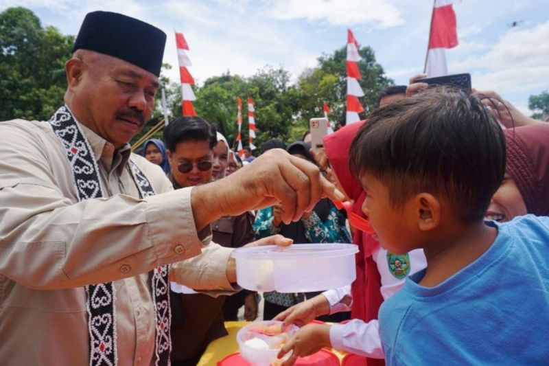 Bupati Kukar Edi Damansyah menyuapi makanan tambahan untuk anak di Amborawang Barat, Kecamatan Samboja Darat, Kukar. (Antara/ HO Prokom Kukar)