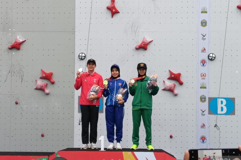 Rajiah Sallsabillah (tengah), Desak Made Rita Kusuma Dewi (kiri), dan Amanda Narda yang masing-masing meraih medali emas, perak, dan perunggu nomor speed WR perorangan cabang olahraga panjat tebing pada PON Aceh-Sumatra Utara 2024, di Banda Aceh, Rabu (11/9/2024). (ANTARA/Zuhdiar Laeis)