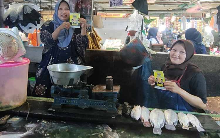Pedagang ikan Pasar Kahayan saat menunjukkan stiker Calon Gubernur dan Wakil Gubernur Kalteng Abdul Razak dan Sri Suwanto (Foto : PATHUR)