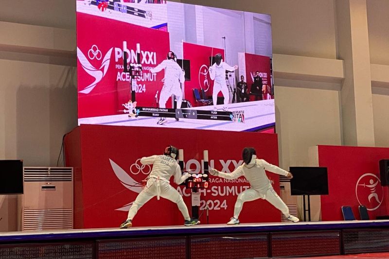 Atlet anggar Riau Muhammad Fatah Prassetyo (kiri) dan atlet anggar Aceh Yudi Anggara Putra (kanan) saat bertanding di babak final nomor floret perorangan putra pada PON XXI Aceh-Sumut 2024 di GOR Anggar Komplek Stadion Harapan Bangsa, Banda Aceh, Kamis (12/9/2024). (ANTARA/Rizka Khaerunnisa)