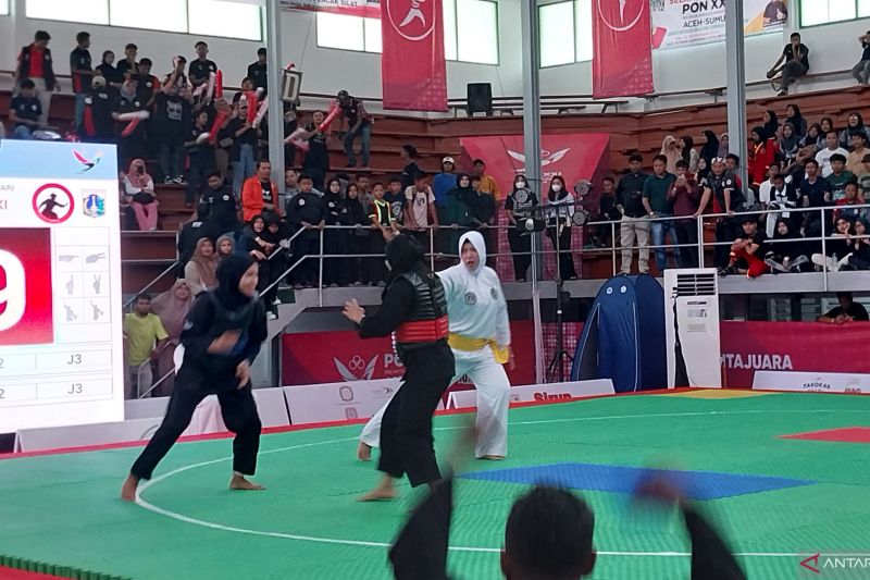 Pesilat putri dari Nusa Tenggara Timur Andini Cahyadewi Alkis (kir) bertanding melawan wakil Jakarta Suci Wulandari dalam laga final kelas A +44 s/d 50kg putri cabang pencak silat PON Aceh-Sumut 2024 di GOR Veteran, Medan, Jumat (13/9/2024). (ANTARA/Aloysius Lewokeda)