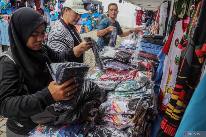 Pembeli memilih jersey bertemakan PON XXI Aceh-Sumut 2024 yang dijual Di GOR Veteran, Medan, Sumatera Utara, Selasa (10/9/2024). . ANTARA FOTO/Yulius Satria WIjaya/nz (