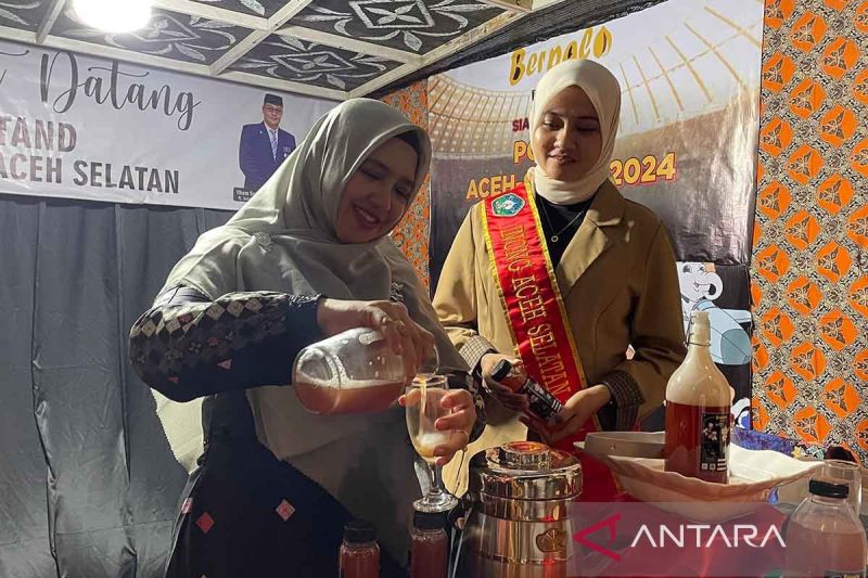 Pj Ketua Dekranasda Aceh Selatan Yuliani Irvana menuangkan berPala, minuman fermentasi buah pala pada Expo UMKM PON XXI Aceh-Sumut di Banda Aceh. ANTARA/Risky Hardian Saputra