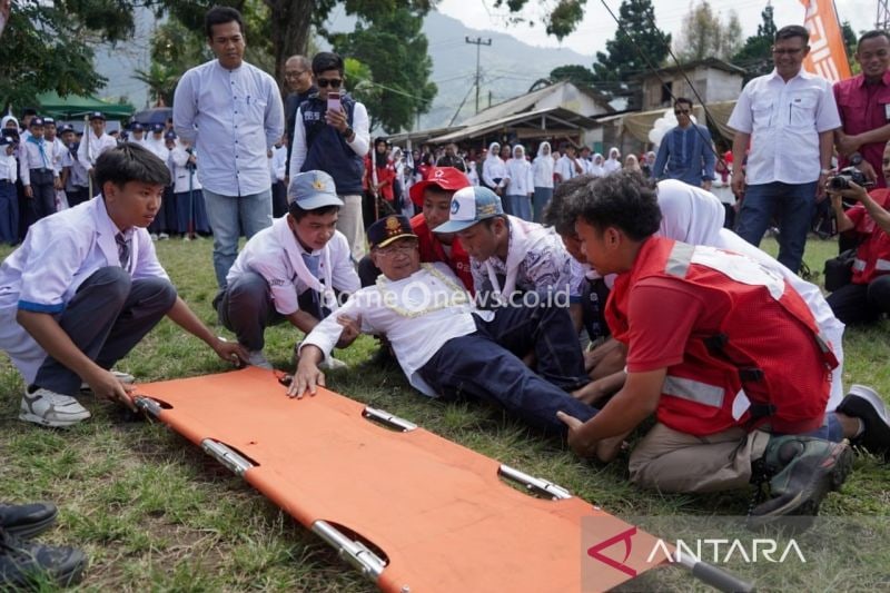 Bupati Cianjur Jawa Barat Herman Suherman saat memberikan kejutan pada ribuan peserta pelatihan dan pelantikan Palang Merah Remaja se-Cianjur, dengan berpura-pura sakit usai membuka acara di Bumi Perkemahan Mandala Kitri Cibodas, Sabtu (14/9/2024). ANTARA/Ahmad Fikri.