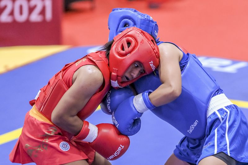 Atlet wushu putri Jatim Friska Ria Wibowo (kiri) berusaha memukul Atlet wushu putri Sumut Junita Malau (kanan) saat bertanding pada semifinal Wushu Sanda Putri nomor 48 Kg PON Papua di Gor Futsal Dispora, Kabupaten Merauke, Papua, Jumat (1/10/2021). ANTARA FOTO/Galih Pradipta/YU (ANTARA FOTO/GALIH PRADIPTA)