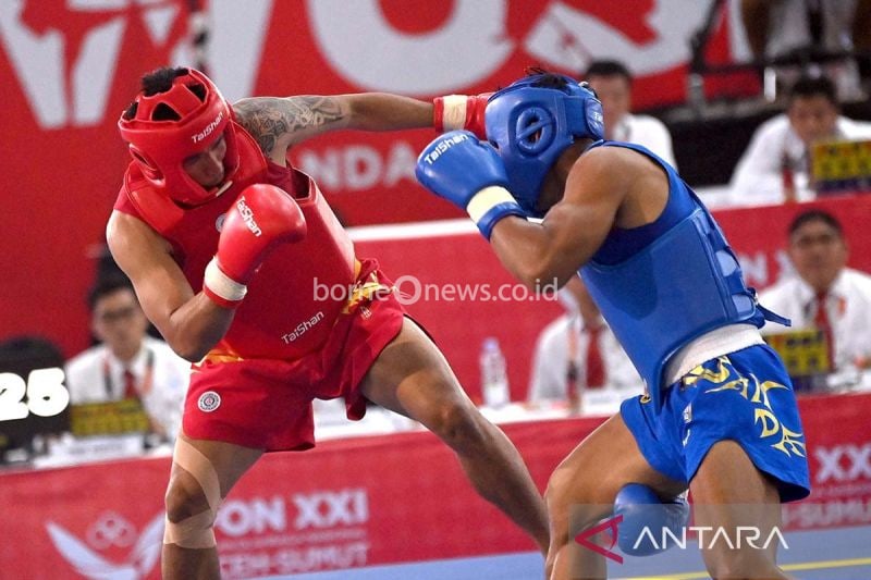 Atlet wushu Jawa Tengah Puja Riyaya (kiri) melancarkan pukulan kearaah atlet wushu Sumut Roberto Manik (kanan) pada final wushu sanda kelompok 75 kg putra PON XXI Aceh-Sumut 2024 di Gedung Serbaguna Dinas Pemuda dan Olahraga Sumatera Utara (Disporasu), Deli Serdang, Sumatera Utara, Minggu (15/9/2024). ANTARA FOTO/Yulius Satria Wijaya/nz/aa.