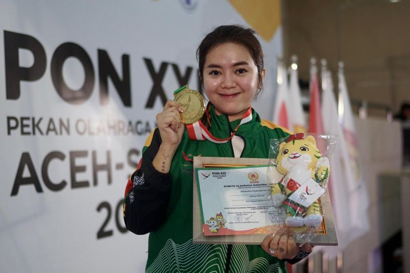 Pebiliar Papua Pegunungan Kenny TIrza Chandra berfoto sambil memegang medali emasi yang diraih pada nomor 10 ball single putra di Pardede Hall, Medan, Minggu (15/9/2024). Kenny meraih emas setelah menumbangkan lawan asal Jawa Timur Emilia Putri Rahmanda dalam partai final dengan skor akhir 7-5. (ANTARA/HO-PB PON/Chalid Nasution)
