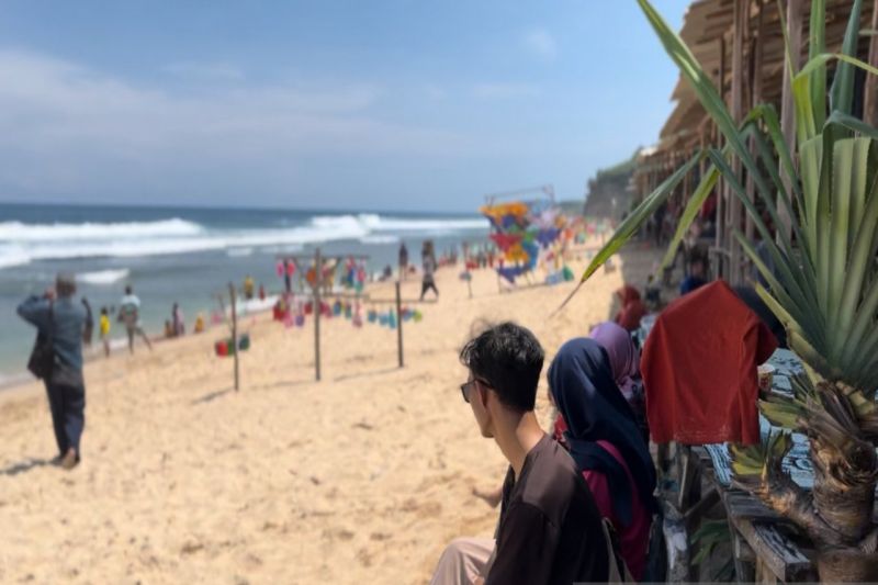 Wisatawan bermain air di bibir Pantai Ngandong, Kabupaten Gunungkidul, DIY. (ANTARA/Sutarmi)