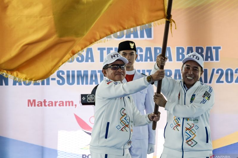 Penjabat Gubernur NTB Hassanudin (kiri) bersama Ketua KONI NTB Mori Hanafi (kanan) membawa bendera logo Provinsi NTB saat acara pelepasan kontingen Nusa Tenggara Barat untuk PON XXI Aceh-Sumut di Gelanggang Pemuda, Mataram, NTB, Rabu (28/8/2024). ANTARA FOTO/Ahmad Subaidi