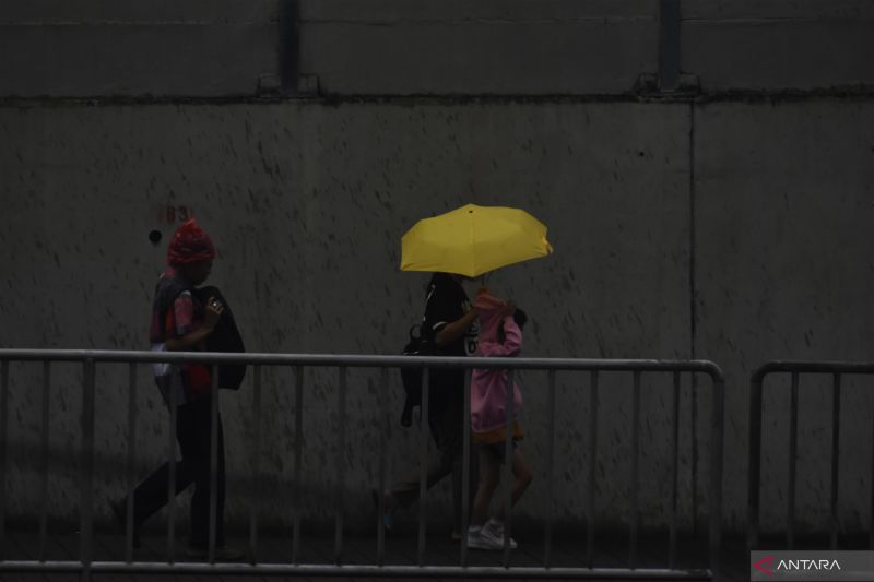Arsip foto - Pejalan kaki menggunakan payung untuk berlindung dari hujan saat melintas di pedestrian MRT Lebak Bulus, Jakarta Selatan, Jumat (1/12/2023). (ANTARA /M RIEZKO BIMA ELKO PRASETYO)