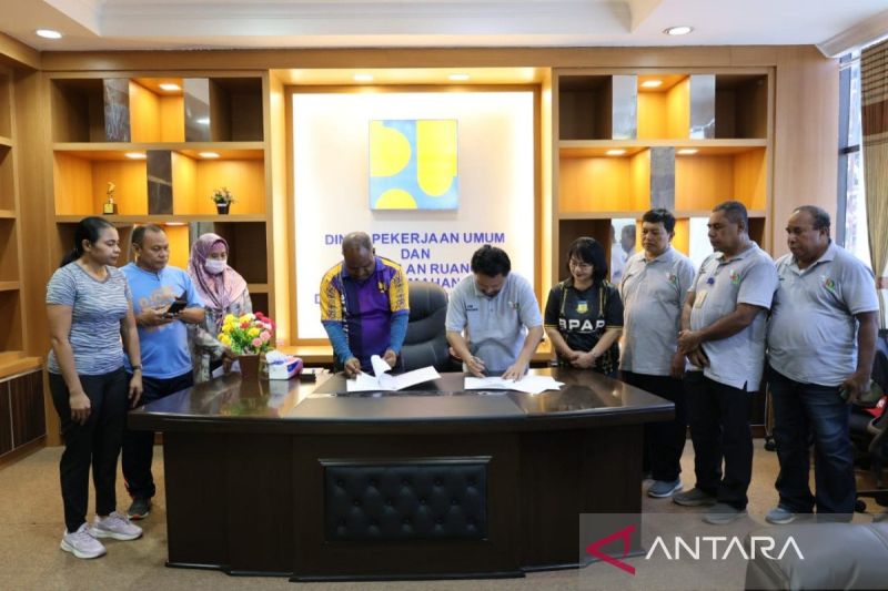 Kepala Dinas Pekerjaan Umum Penataan Ruang, Perumahan dan Kawasan permukiman Provinsi Papua Amos Wenda bersama Direktur Utama PT Jamkrida Papua Desti Pongsikabe saat melakulan penandatanganan di Kantor PU Provinsi Papua, Jumat (20/9). (ANTARA/Qadri Pratiwi)