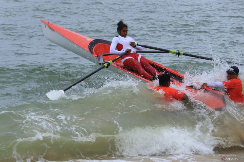 Atlet dayung DKI Jakarta Lola Hanarina Blegur yang turun di nomor rowing beach sprint mencoba menghadang ombak pada babak final yang berlangsung di Pantai Pulau Kapuk, Aceh Besar. (ANTARA/Muhammad Zulfikar).