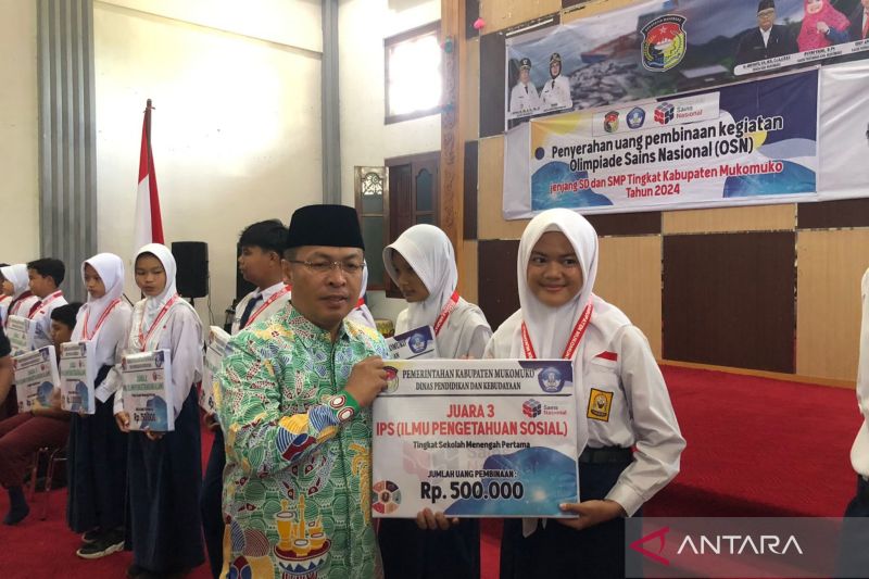 Bupati Mukomuko Sapuan menyerahkan bantuan uang pembinaan kepada siswa yang menjadi pemenang OSN, Jumat (20/9/2024) ANTARA/Ferri.