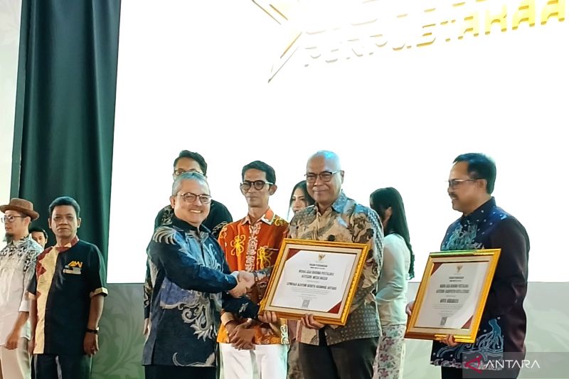 Pelaksana Tugas Kepala Perpustakaan Nasional E Aminudin Aziz memberikan penghargaan Nugra Jasa Dharma Pustaloka (NJDP) 2024 kepada Direktur Utama LKBN ANTARA Akhmad Munir di Balai Sudirman, Jakarta, pada Jumat (20/9/2024). (ANTARA/Lintang Budiyanti Prameswari)