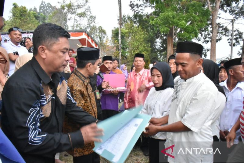 Bupati Gorontalo Nelson Pomalingo didampingi Plt Sekda Kabupaten Gorontalo Haris Tome menyerahkan buku nikah di Desa Dulamayo, Kabupaten Gorontalo, Gorontalo. ANTARA/HO-Diskominfo Kabupaten Gorontalo