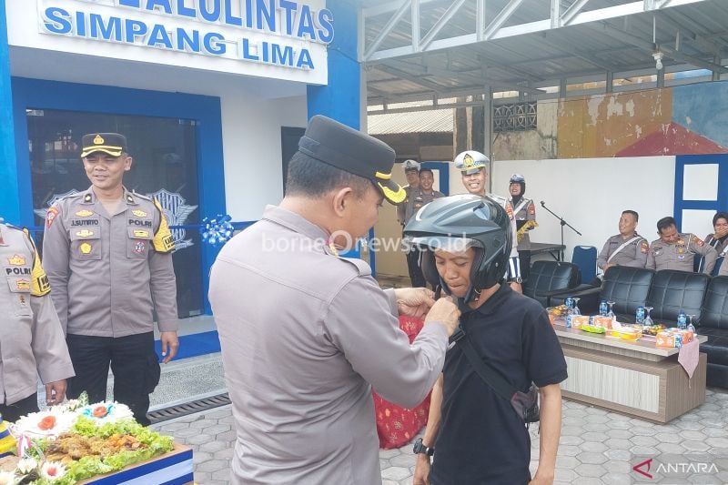 Kapolresta Bengkulu Kombes Pol. Deddy Nata memakaikan helm kepada salah seorang pengendara sebagai salah satu upaya sosialisasi tertib berkendara dan juga mendekatkan layanan lalu lintas ke pengguna jalan di Bengkulu, Senin. (23/9/2024) (ANTARA/Boyke Ledy Watra)