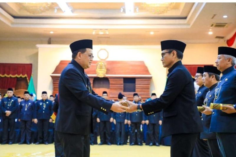 Penjabat Gubernur Jawa Timur Adhy Karyono (kiri) menyerahkan SK perpanjangan masa jabatan Penjabat Bupati Tulungagung Heru Suseno di Gedung Negara Grahadi, Surabaya, Selasa (24/9/2024). (ANTARA/HO - Prokopim Tulungagung)