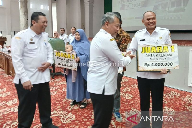 Kepala Dinas Penanaman Modal dan Pelayanan Terpadu Satu Pintu (DPMPTSP) Kabupaten Temanggung Dwi Sukarmei (kanan) menerima penghargaan sebagai juara I Krenova Kabupaten Temanggung tahun 2024 dari Penjabat Bupati Temanggung Hery Agung Prabowo. ANTARA/Heru Suyitno