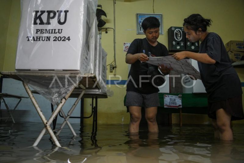 Dua petugas memeriksa surat suara di Tempat Pemungutan Suara (TPS) 039 yang terendam banjir di Duri Kepa, Kebon Jeruk, Jakarta, Rabu (14/2/2024). ANTARA FOTO/Sulthony Hasanuddin/tom.