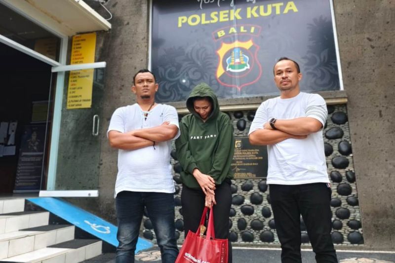 Kasat Reskrim Polres Nagan Raya, Aceh, Iptu Vitra Ramadani (kanan) memperlihatkan tersangka ND (27 tahun), saat diamankan di Polsek Kuta, Denpasar, Provinsi Bali seusai ditangkap terkait kasus arisan bodong, Minggu (23/9/2024). (ANTARA/HO)