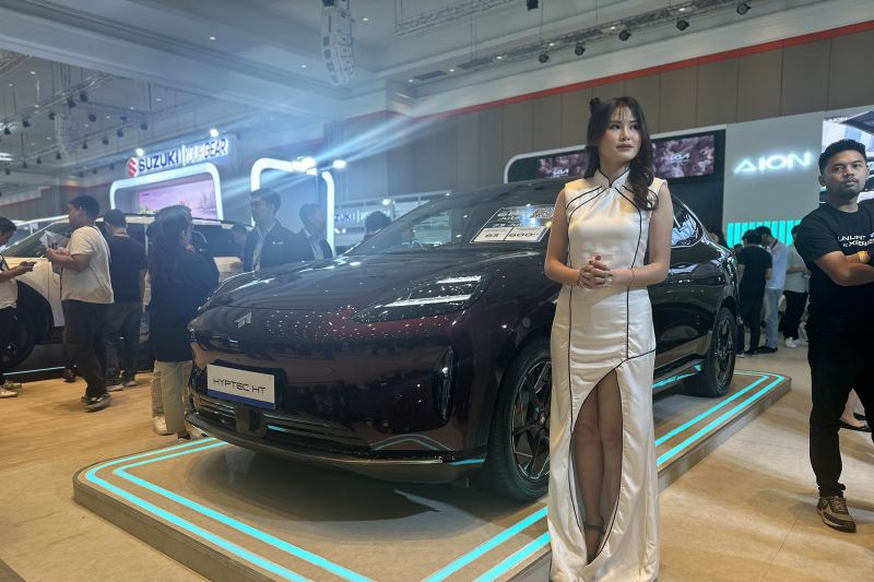 Seorang model berdiri di dekat mobil listrik AION ???????Hyptec HT yang dipamerkan di Gaikindo Indonesia International Auto Show (GIIAS) Bandung di Sudirman Grand Ballroom, Bandung, Jawa Barat, Rabu (25/9/2024). (ANTARA/Pamela Sakina)