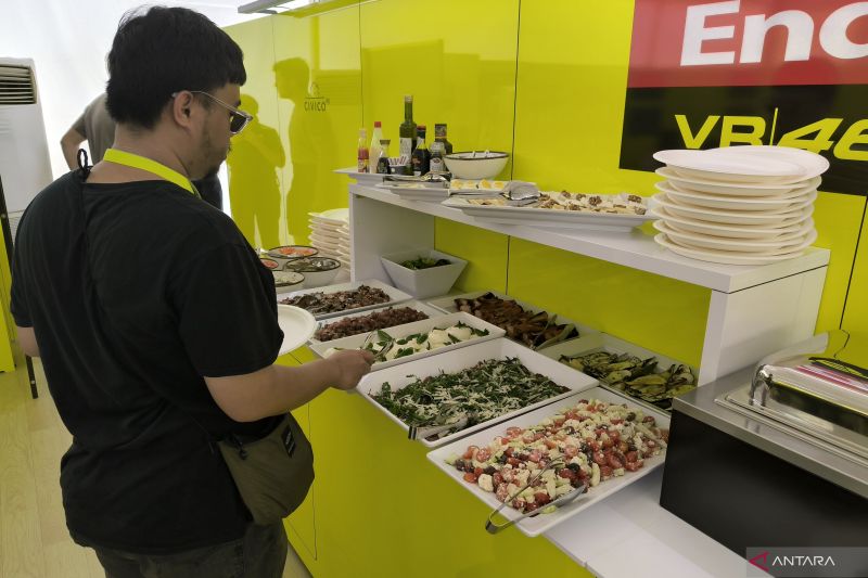 Seorang ofisial mengambil makanan di Ruang Ramah Tamah Pertamina Enduro VR46 Racing Team, Sirkuit Internasional Pertamina Mandalika, Nusa Tenggara Barat, Sabtu (28/9/2024). (ANTARA/Michael Siahaan)