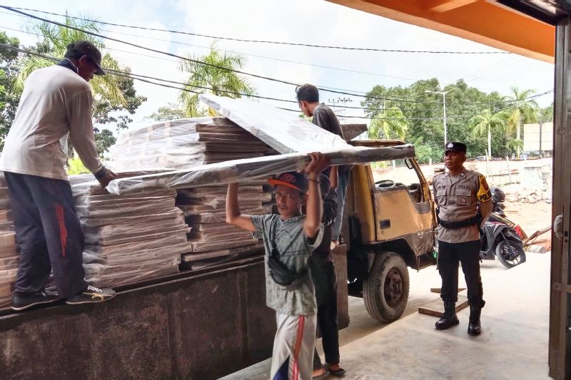 Anggota Polres Karimun mengawal proses distribusi logistik bilik suara dan kotak suara dari pelabuhan ke gudang KPU Karimun, Minggu (29/9/2024). (ANTARA/HO-Polres Karimun)