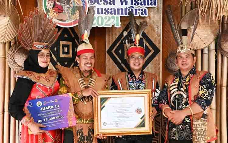 Penjabat Bupati Lamandau Said Salim menunjukkan penghargaan di ajang lomba Desa Wisata Nusantara Tahun 2024. (FOTO : HENDI NURFALAH)
