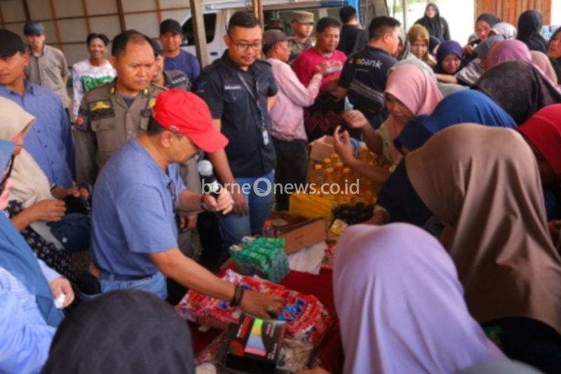 Pj Bupati H Syamsir Rahman (topi merah) bersama Pj Ketua Tim Penggerak PKK Tala Hj Rizki Yulia Syamsir Rahman saat ikut terjun langsung melayani masyarakat yang berbelanja di pasar murah. (ANTARA/HO-Diskominfo Tanah Laut)