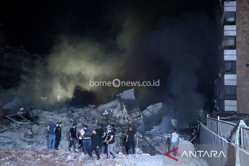 Warga terlihat di lokasi serangan udara Israel yang menargetkan markas besar Hizbullah di Beirut, Lebanon, Kamis (27/9/2024). ANTARA FOTO/Bilal Jawich/Xinhua/Spt.