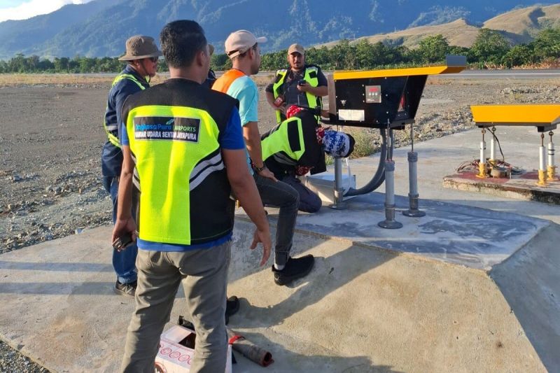 Petugas Bandara Internasional Sentani saat memasang alat sistem lampu atau Precision Approach Path Indicator (PAPI) di kedua ujung runway. (ANTARA/HO-Humas Bandara Sentani)