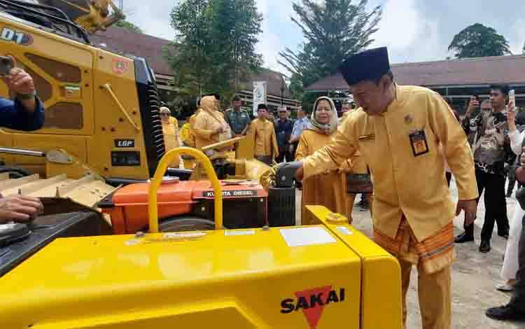 Kepala Dinas PUPR Kobar Muhammad Hasyim Muallim saat melakukan rangkaian adat Tompung Tawar di Alat berat. (Foto : DANANG)
