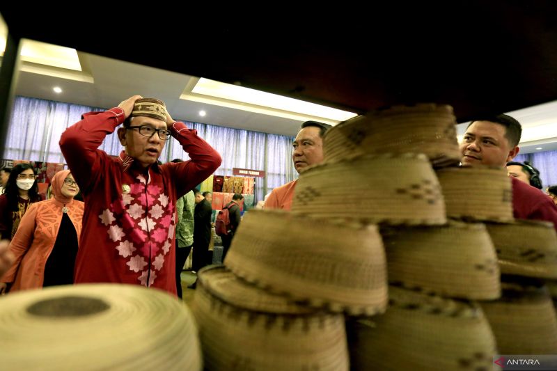 Penjabat Gubernur Gorontalo Rudy Salahuddin (kiri) mencoba upiah karanji pada Hulonthalo Art and Craft Festival (HACF) 2024 di Kota Gorontalo, Gorontalo, Kamis (3/10/2024). Pemerintah Provinsi Gorontalo, Kantor Perwakilan Bank Indonesia (BI) Gorontalo bersama Dewan Kerajinan Nasional Daerah (Dekranasda) Provinsi Gorontalo menggelar HACF tahun 2024 untuk mendorong potensi ekonomi kreatif yang diikuti oleh 118 UMKM mulai dari olahan pangan, kerajinan tangan hingga pertanian. ANTARA/Adiwinata Solih