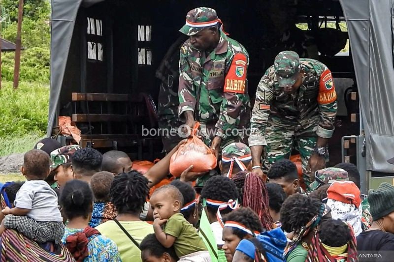 Prajurit TNI Satgas Yonif PR 503/MK Habema, anggota Satgas Elang dan Satgas Damai Cartenz memberikan bantuan sembako kepada masyarakat Nduga usai mengucapkan ikrar kecintaan terhadap NKRI di Balai Kesehatan Puskesmas Batas Batu, Nduga, Kenyam, Papua Pegunungan, Kamis (3/10/2024). . ANTARA FOTO/Yongki/Adm/Spt. (ANTARA FOTO/YONGKI)