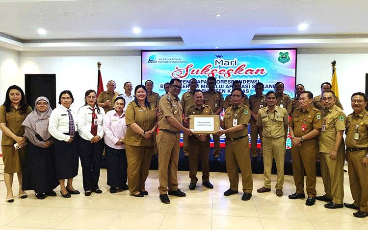 Pj Bupati Kapuas, Darliansjah saat menyerahkan laptop terkait digitalisasi arsip kepada Kepala Disarpustaka Kapuas, Suwarno Muriyat. (FOTO: IST)