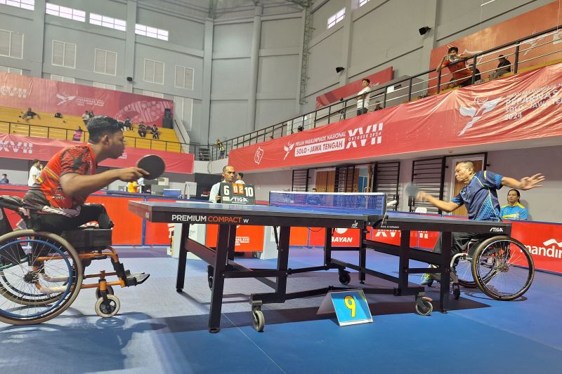 Atlet para tenis meja Jawa Tengah, Isna Priyanto (kanan) melepaskan serve saat menghadapi Kalimantan Barat, Muhammad Untung (kiri) pada pertandingan babak delapan besar tunggal putra kategori nasional kelas 5 Pekan Paralimpiade Nasional (Peparnas) XVII Solo 2024 di GOR Bung Karno, Surakarta, Jawa Tengah, Selasa (08/10/2024). (ANTARA/FAJAR SATRIYO)