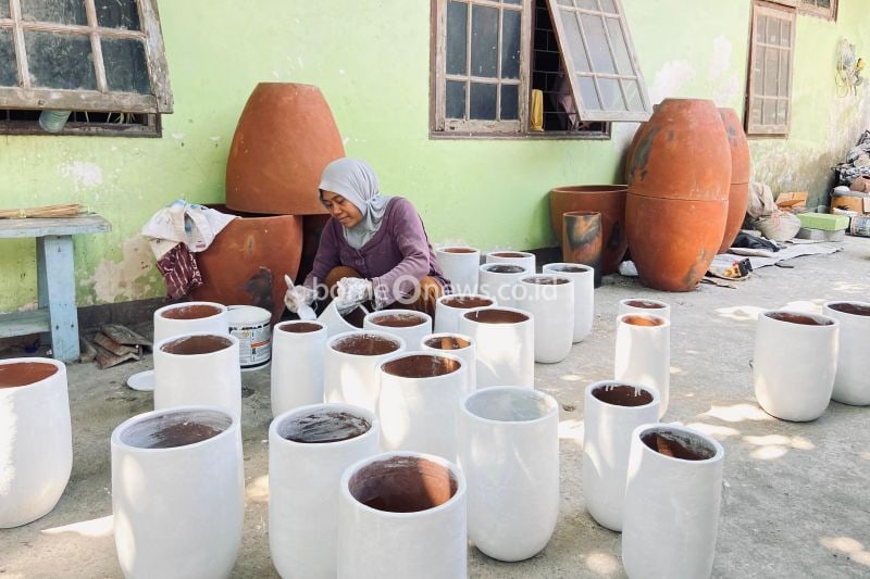 Seorang perajin sedang mengecat gerabah di Desa Banyumulek, Kabupaten Lombok Barat, Nusa Tenggara Barat, Selasa (8/10/2024). (ANTARA/HO-Elya Yuli Tantina-Mahasiswi PKL IAIH)