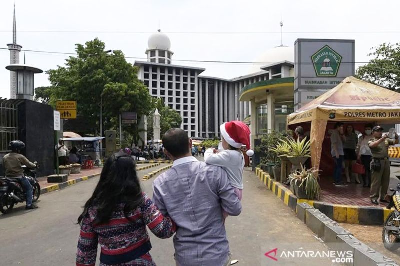 Umat Katolik menuju lokasi parkiran Masjid Istiqlal seusai mengikuti Misa Natal di Gereja Katedral, Jakarta, Jumat (25/12/2022). ANTARA FOTO/Sigid Kurniawan/aww.