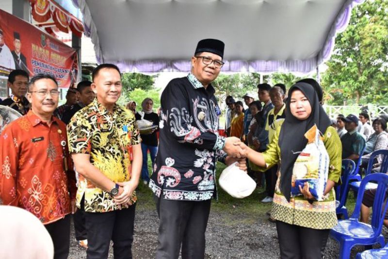 Pj Bupati Kapuas Darlianjsah memberi paket sembako secara simbolis kepada masyarakat dalam kegiatan pasar murah di Kantor Kecamatan Kapuas Hilir, Jumat (11/10/2024). ANTARA/HO-Diskominfosantik Kapuas