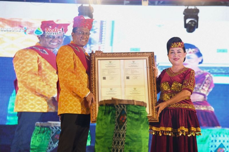 Menkumham Supratman Andi Agtas menyerahkan Sertifikat Kekayaan Intelektual Komunal kepada Pemerintah Kabupaten Poso pada Festival Danau Poso 2024 di Poso, Sulawesi Tengah, Jumat (11/10/2024). (ANTARA/Kemenkumham RI)