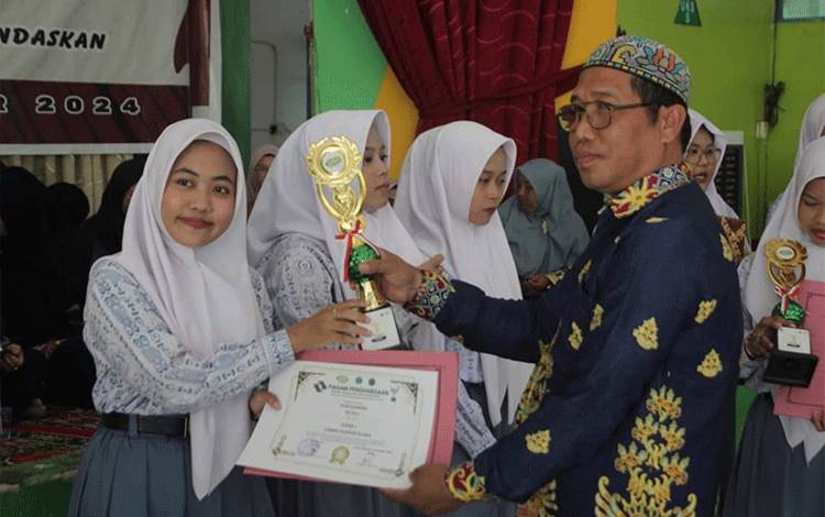 Kepala MAN Kapuas, Ahmad Mulyadi saat penyerahan piala pada penutupan Gebyar Ekskul dan Hari Bahasa. (FOTO: IST)