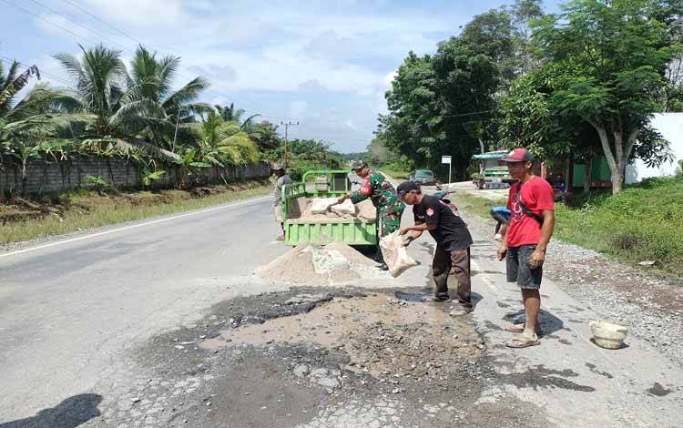 Babinsa dan Warga Gotong Royong Perbaiki Jalan Rusak di Desa Riam Durian